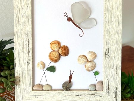 A lovely scene with a butterfly, snail, and flowers, made with seaglass and seashells, perfect as a unique gift!