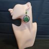 A green lotus flower in earring form