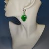 green alien earrings on a mannequin