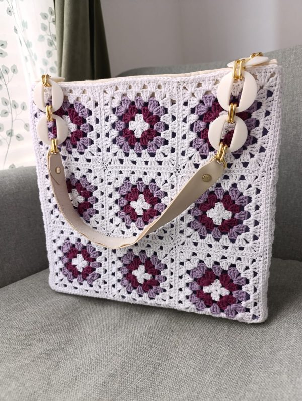 Handmade boho crochet bag in white, purple, and lilac granny squares with magnetic closure