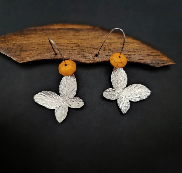 Butterfly hammered earrings with orange howlite stones