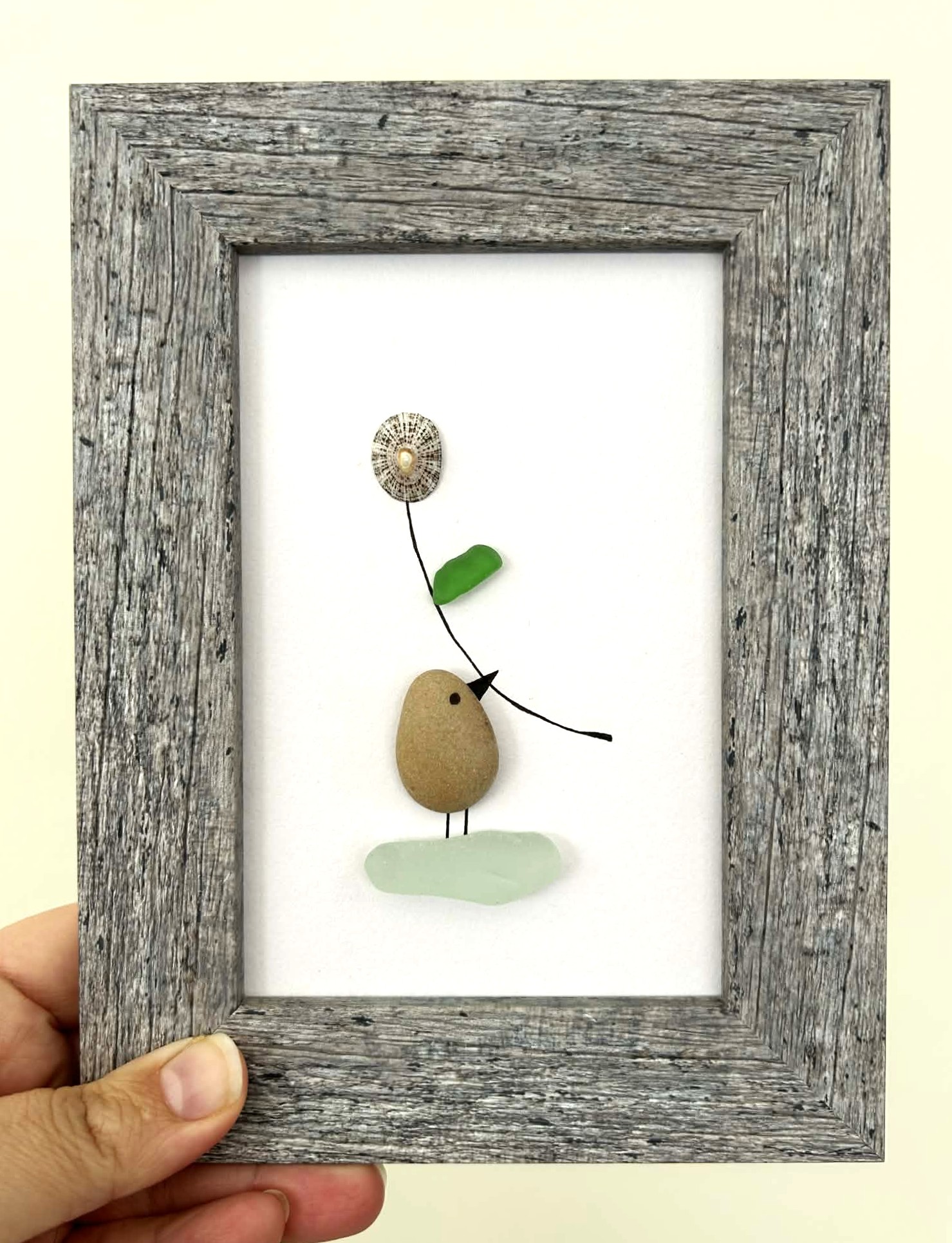 Minimalist Coastal Art – Pebble & Seaglass Scene with a Cute Bird Holding a Flower